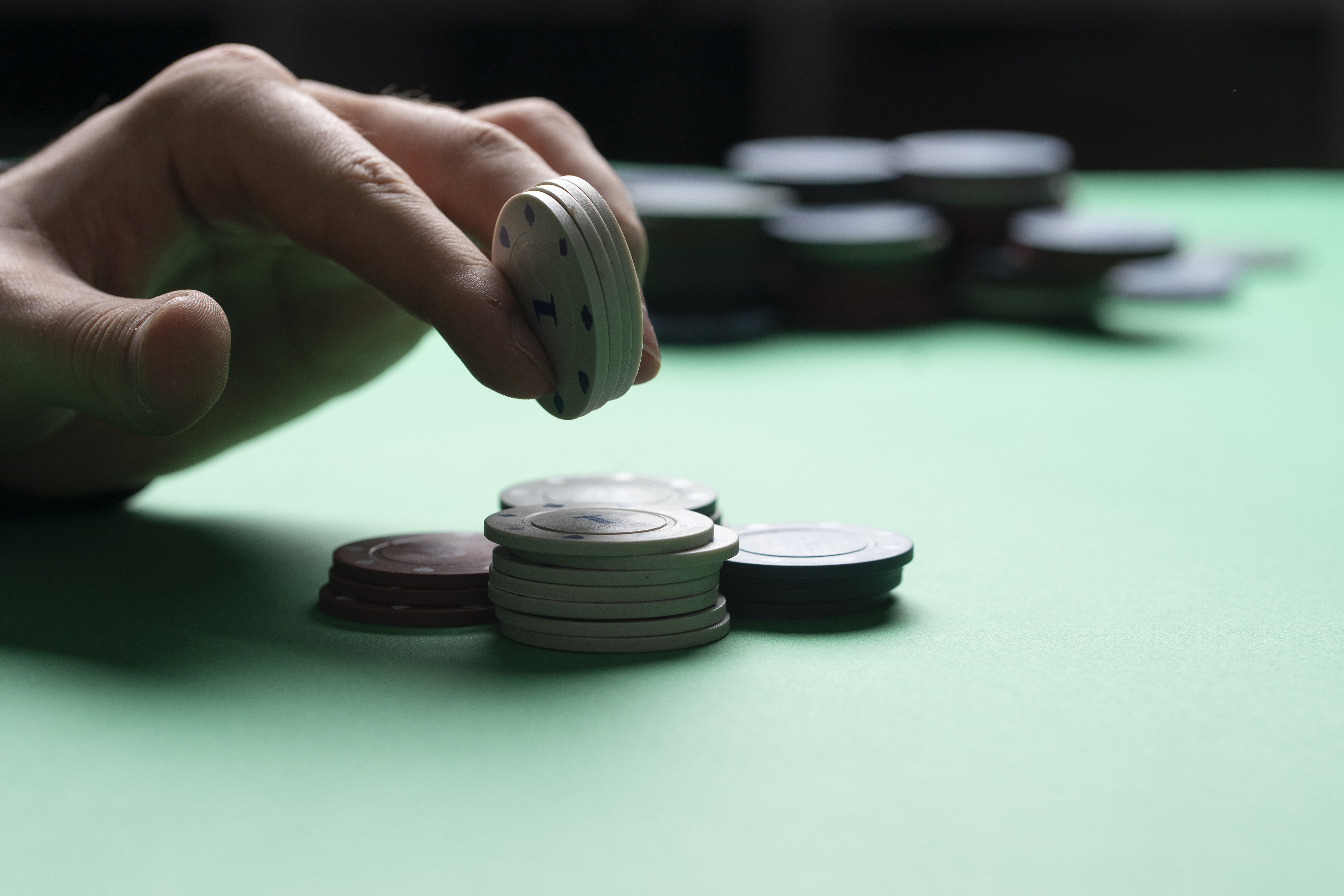 a poker player holding casino chips in hand, winning the game