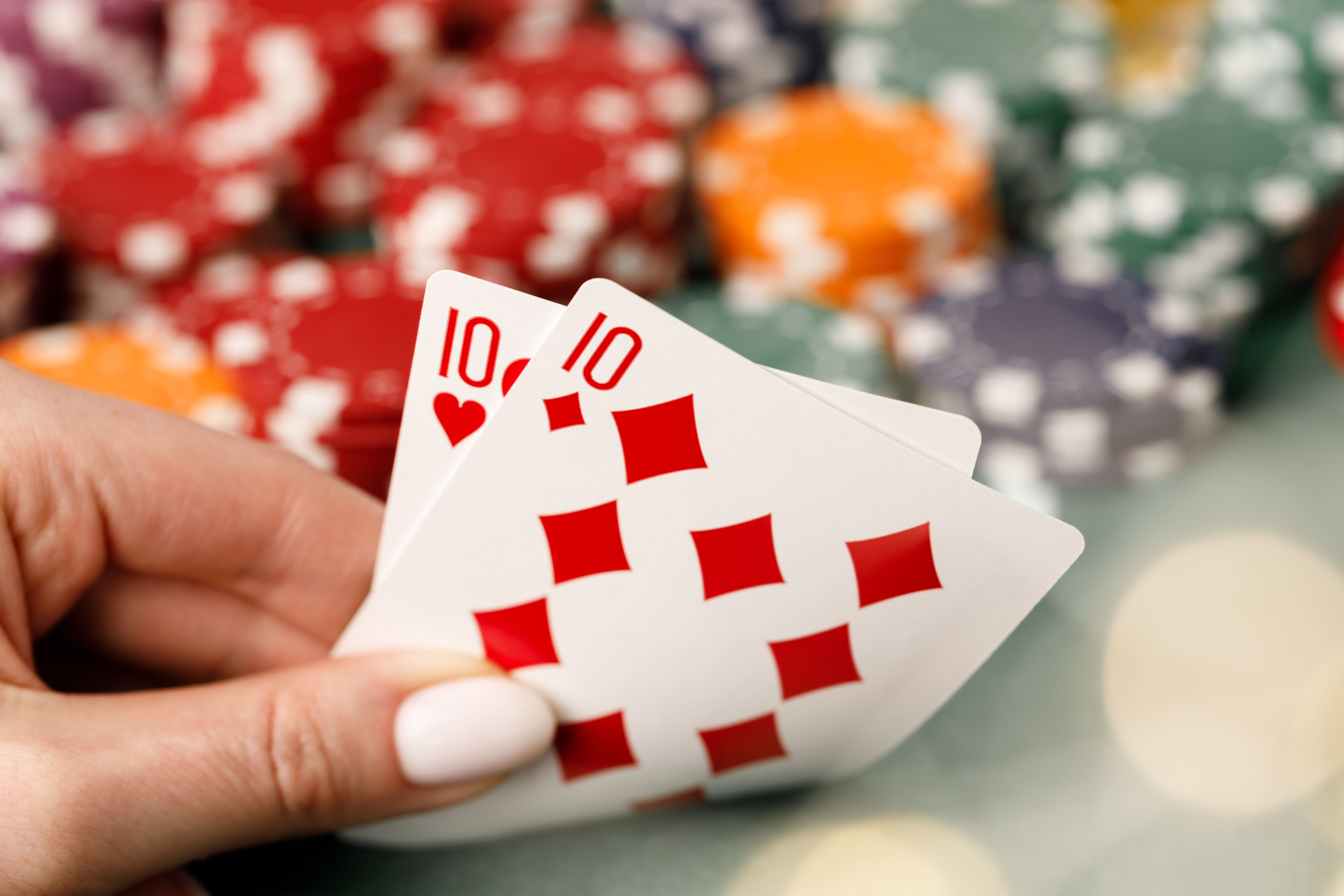 Female hand holding playing cards in casino